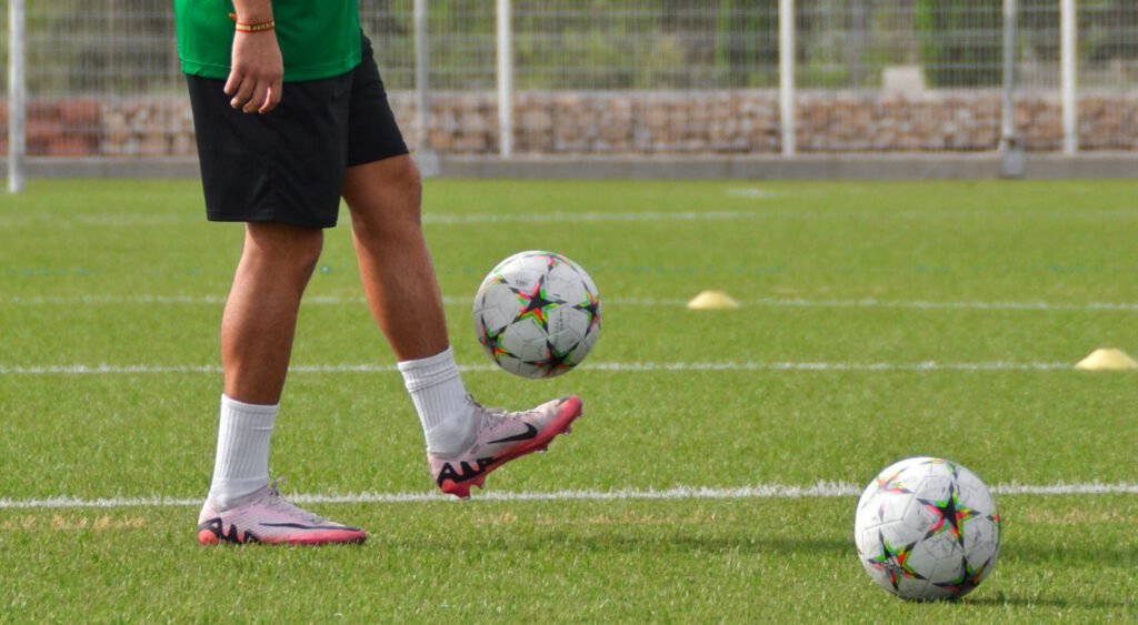 Jugador controlando el balón con la planta del pie durante entrenamiento de fútbol sobre césped artificial